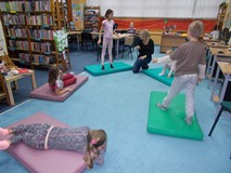 Bibliotekarka przeprowadza z dziećmi zabawę