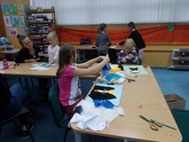Dzieci wykonują prace plastyczne, a rodzic wpiera pracę swojego dziecka